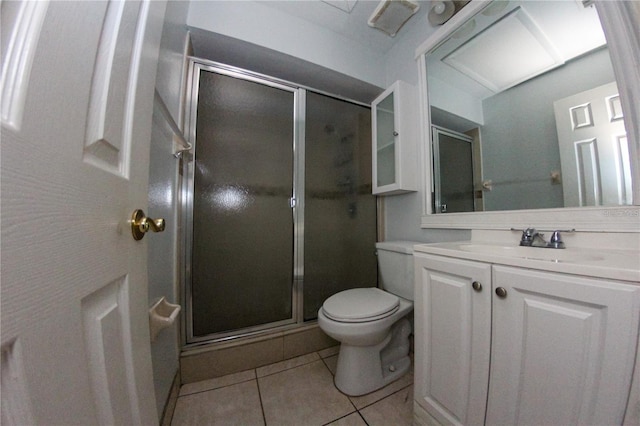 bathroom with tile patterned flooring, vanity, a shower with door, and toilet