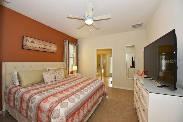 bedroom with ceiling fan, ensuite bath, and light carpet