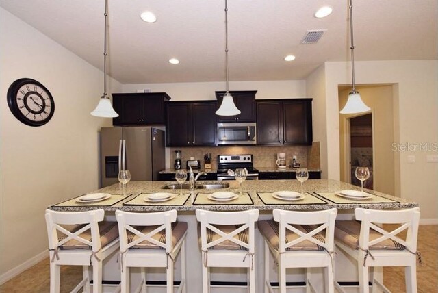 kitchen featuring appliances with stainless steel finishes, decorative light fixtures, and sink