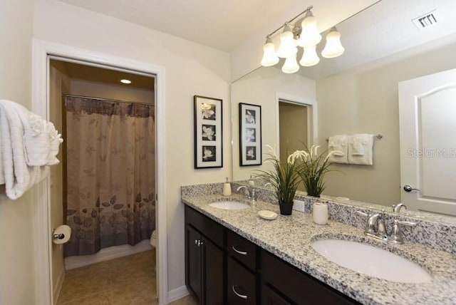 bathroom featuring tile patterned flooring, vanity, toilet, and walk in shower