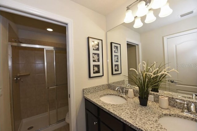 bathroom with vanity, an enclosed shower, and toilet