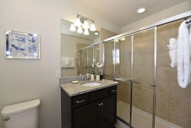 bathroom with walk in shower, vanity, and toilet