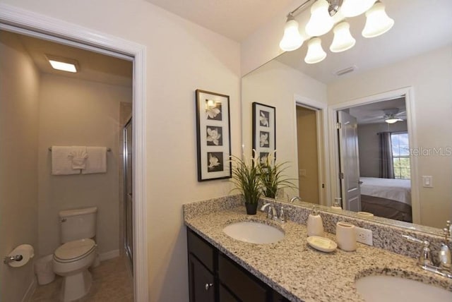 bathroom with vanity, tile patterned floors, a shower with door, and toilet