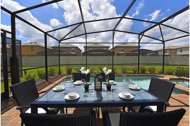 view of patio / terrace featuring a swimming pool with hot tub and a lanai