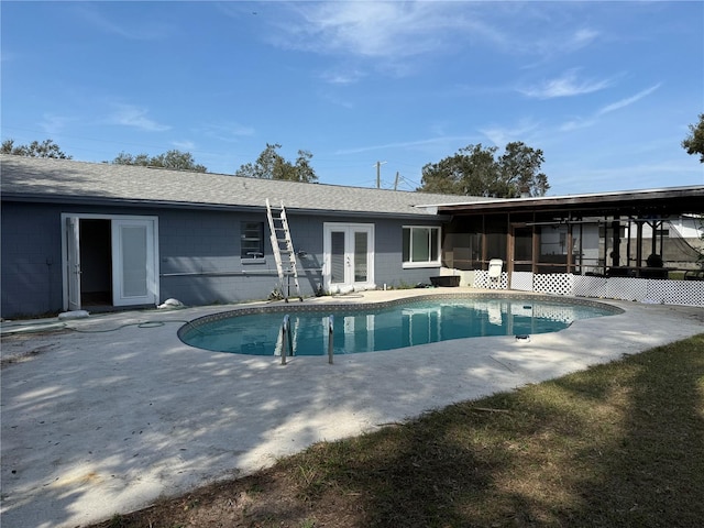 view of swimming pool with a sunroom and french doors