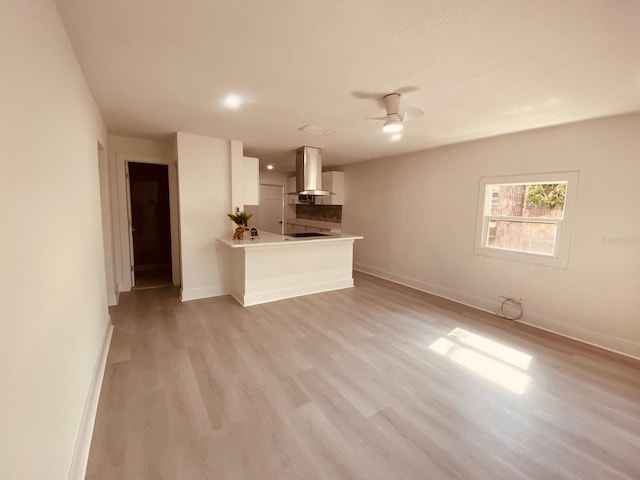 unfurnished living room with ceiling fan and light hardwood / wood-style floors