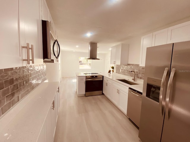 kitchen featuring appliances with stainless steel finishes, sink, white cabinets, island exhaust hood, and light wood-type flooring