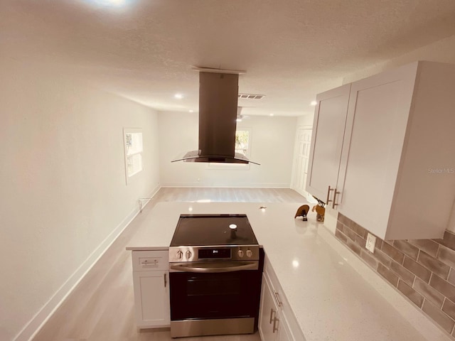 kitchen featuring stainless steel electric range, white cabinetry, tasteful backsplash, a textured ceiling, and island exhaust hood