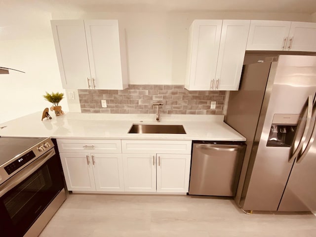 kitchen featuring white cabinetry, sink, decorative backsplash, and stainless steel appliances