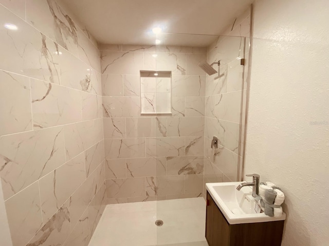 bathroom with vanity and tiled shower