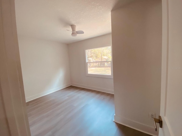 empty room with hardwood / wood-style floors, a textured ceiling, and ceiling fan