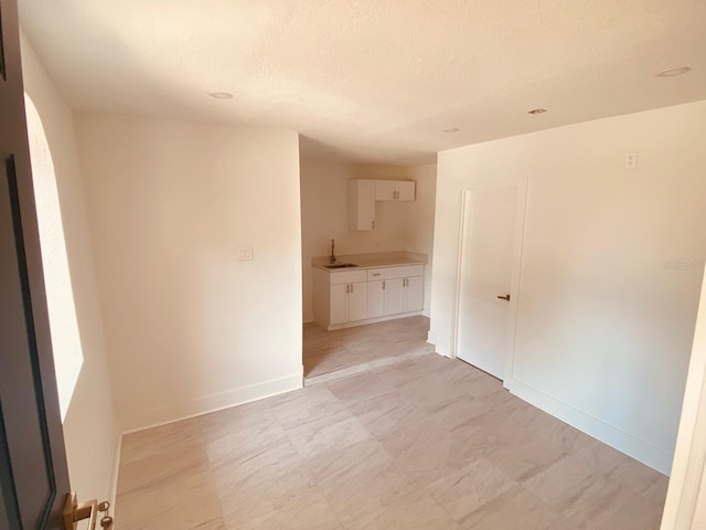 empty room with sink and a textured ceiling