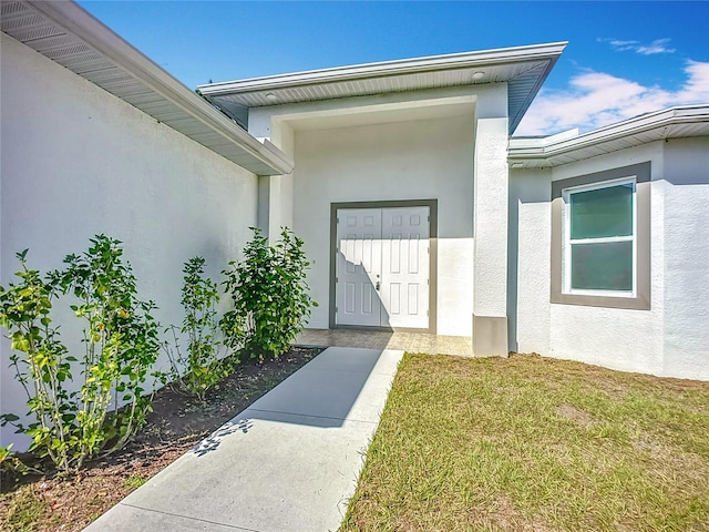 property entrance with a lawn