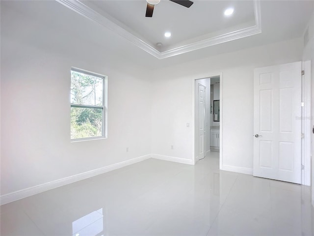 empty room featuring ceiling fan, ornamental molding, and a raised ceiling