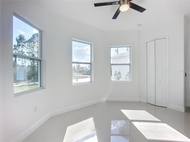 unfurnished bedroom with ceiling fan and a closet