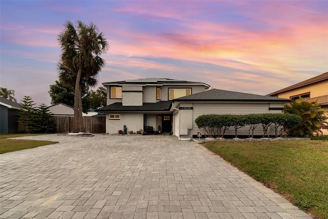 view of front of house with a yard and solar panels