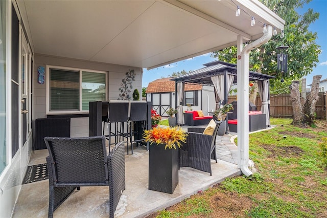 view of patio / terrace with an outdoor living space, a gazebo, a storage shed, and an outdoor bar