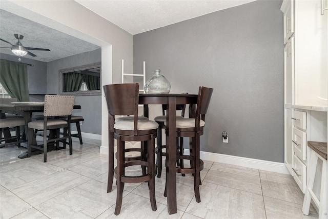 dining room featuring a textured ceiling and ceiling fan