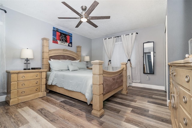 bedroom featuring dark hardwood / wood-style flooring, ceiling fan, and a textured ceiling