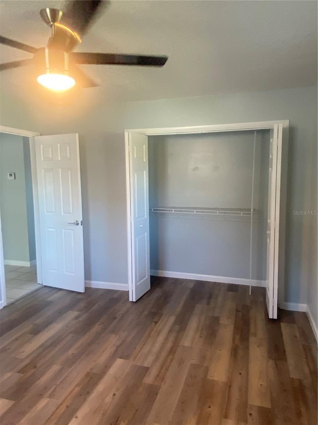 unfurnished bedroom with ceiling fan, dark hardwood / wood-style flooring, and a closet