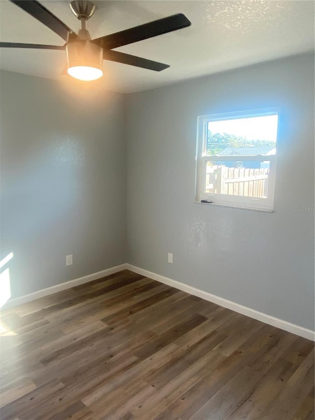 spare room with dark wood-type flooring and ceiling fan