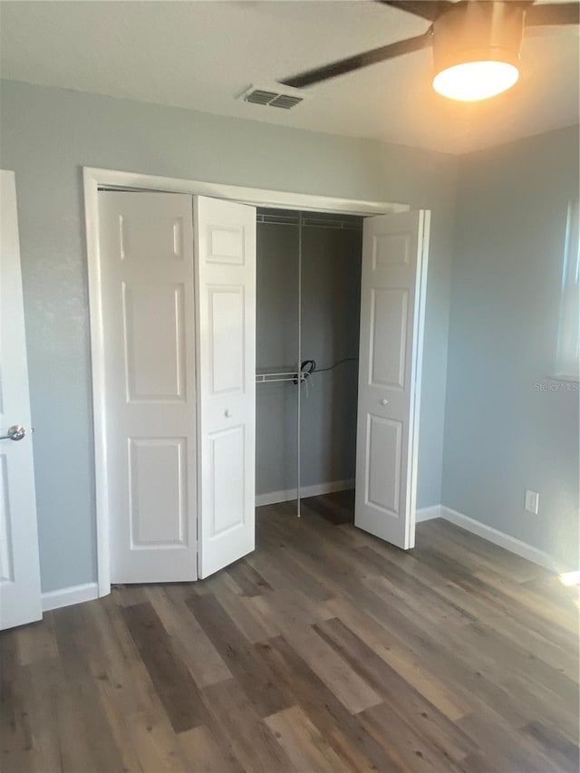 unfurnished bedroom with dark wood-type flooring and a closet