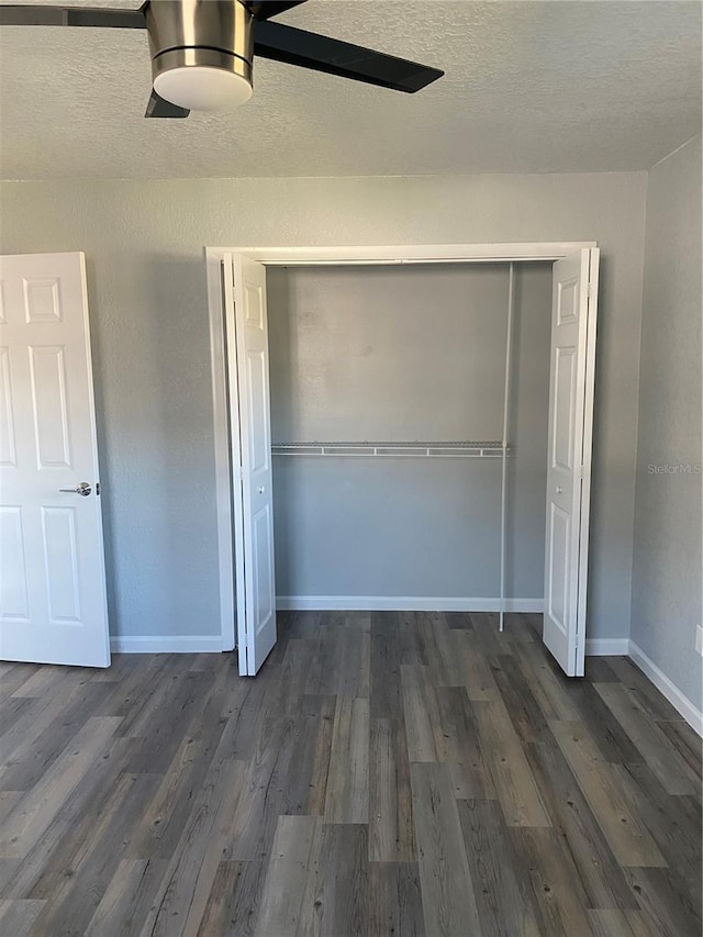 unfurnished bedroom with dark wood-type flooring, ceiling fan, and a closet