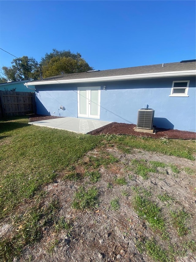 back of property featuring central AC unit, a yard, and a patio