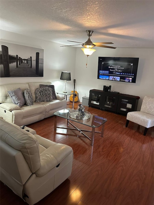 living room with ceiling fan, wood-type flooring, and a textured ceiling