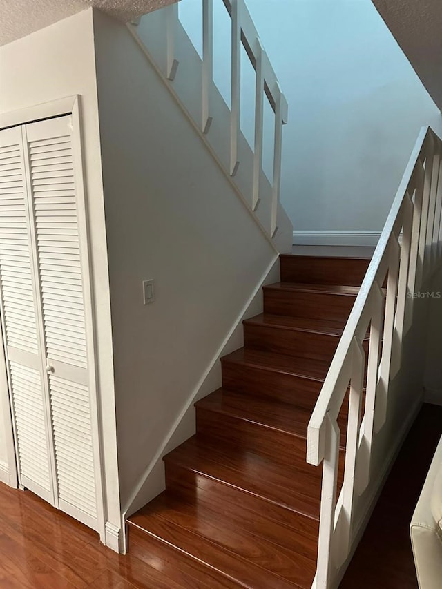 staircase featuring hardwood / wood-style flooring and a textured ceiling