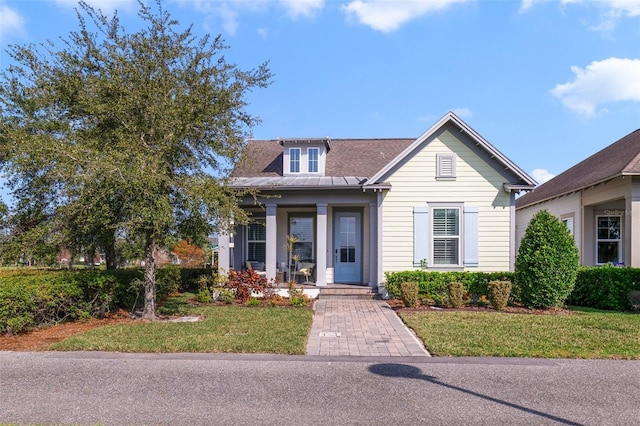 bungalow-style house featuring covered porch and a front lawn