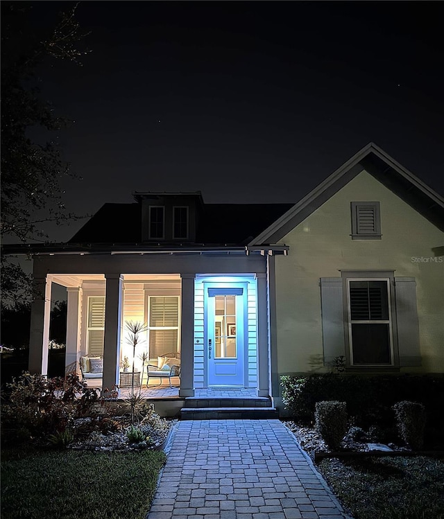 exterior entry at twilight with covered porch