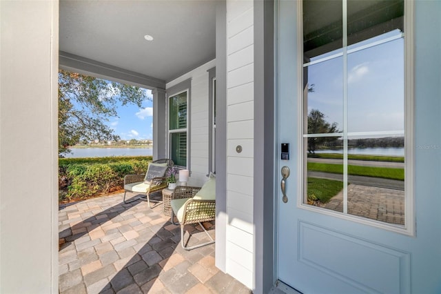 entrance to property featuring a water view and covered porch