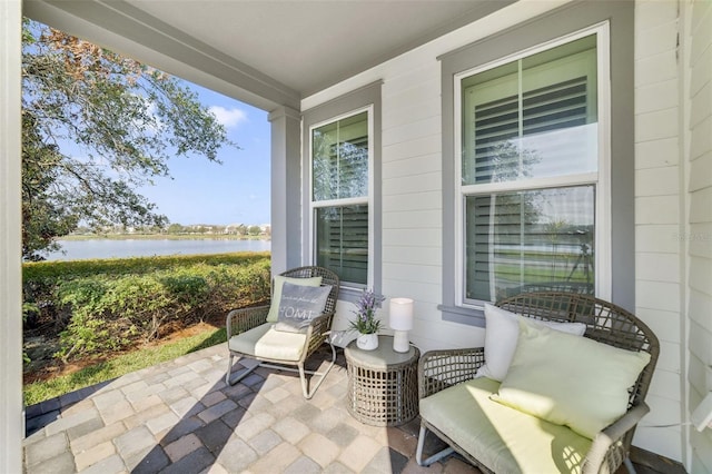 view of patio / terrace featuring a porch and a water view