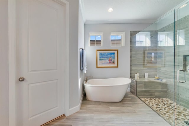 bathroom with ornamental molding and separate shower and tub