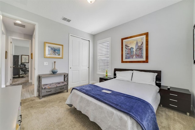 bedroom featuring light colored carpet and a closet