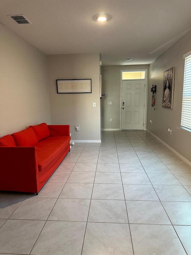 living room featuring light tile patterned flooring and a textured ceiling