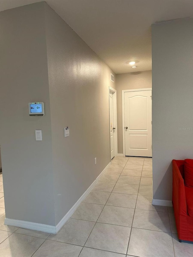 hall featuring light tile patterned flooring