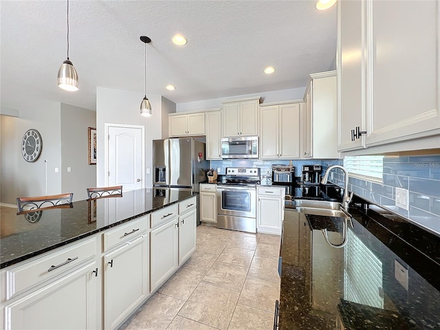 3857 San Isidro Cir, Saint Cloud, FL 34772 - kitchen featuring tasteful backsplash, appliances with stainless steel finishes, dark stone countertops, and decorative light fixtures