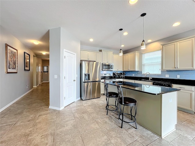 3857 San Isidro Cir, Saint Cloud, FL 34772 - kitchen with stainless steel appliances, cream cabinets, and a center island