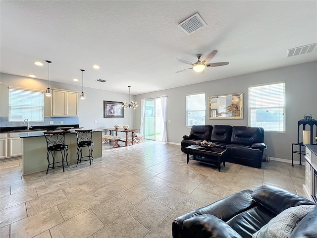 3857 San Isidro Cir, Saint Cloud, FL 34772 - living room with sink, ceiling fan with notable chandelier, and a textured ceiling
