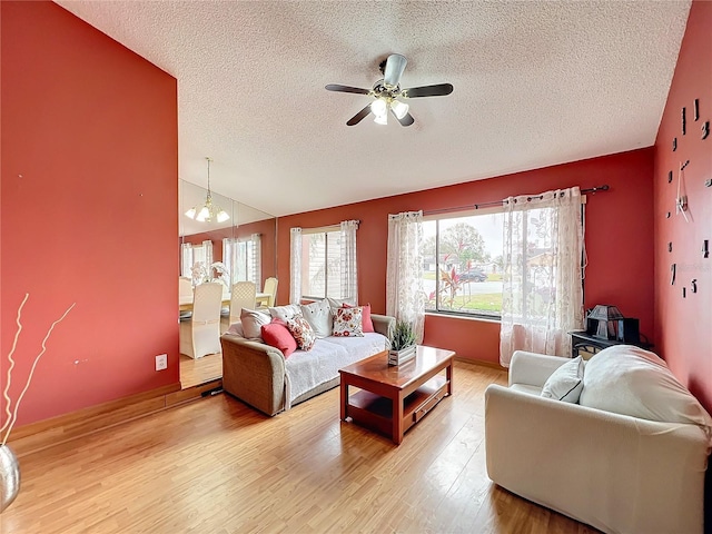 living room with a textured ceiling, wood-type flooring, ceiling fan, and vaulted ceiling