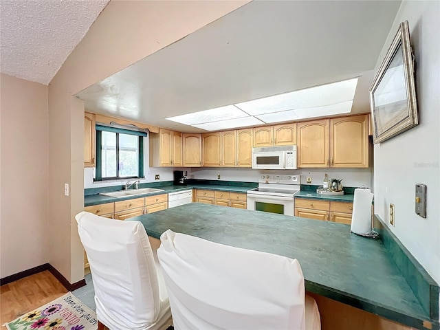 kitchen with white appliances, sink, a textured ceiling, and light wood-type flooring