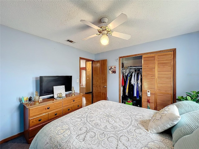 bedroom with ceiling fan, a closet, and a textured ceiling