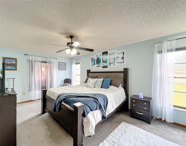 bedroom with light colored carpet, a textured ceiling, and ceiling fan