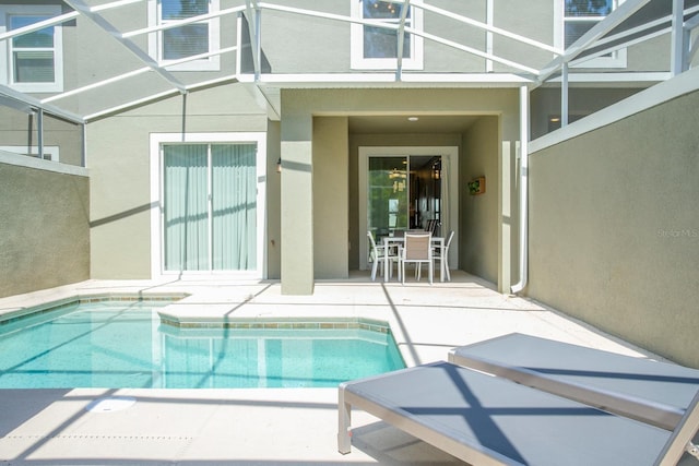 view of pool with a patio area and glass enclosure