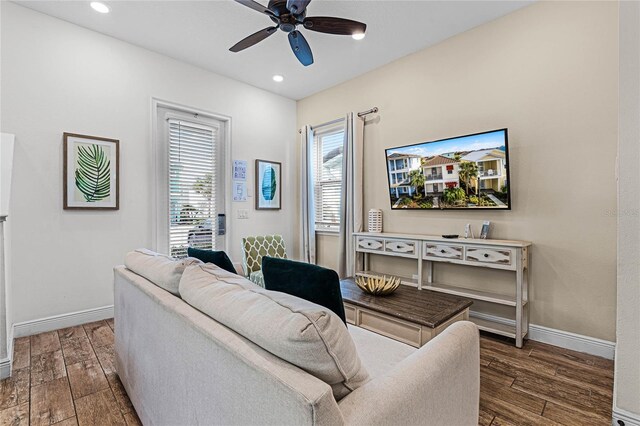 living room featuring dark hardwood / wood-style flooring and ceiling fan