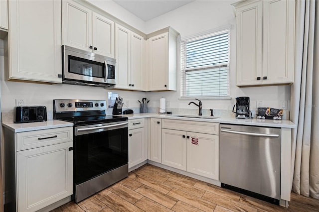 kitchen featuring white cabinetry, stainless steel appliances, and sink