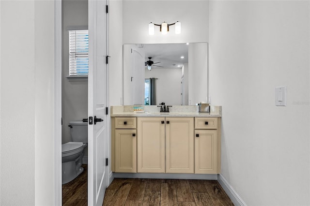 bathroom with hardwood / wood-style flooring, ceiling fan, vanity, and toilet