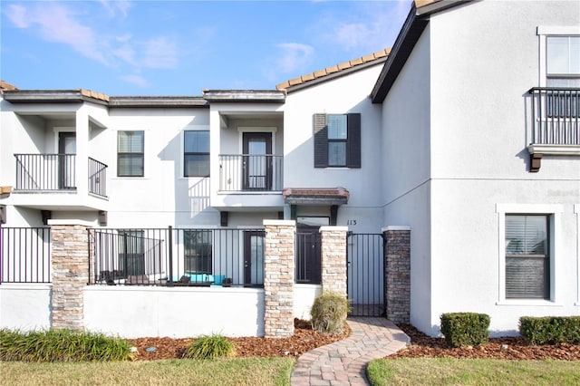 view of front of home featuring stucco siding and stone siding